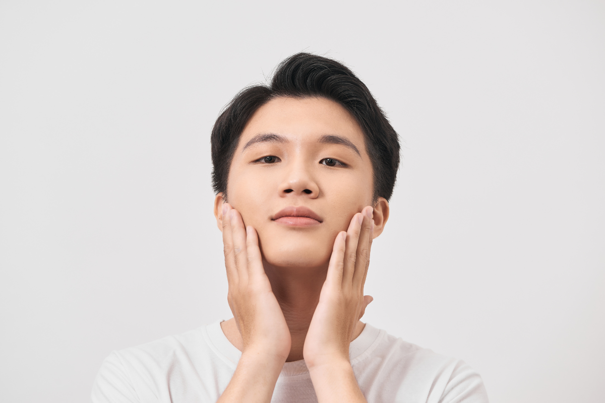 頬を両手で触る男性
