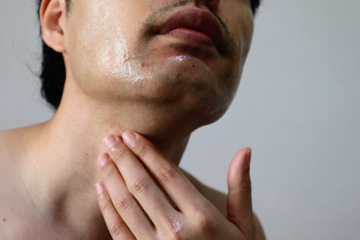 首に手を当てる男性
