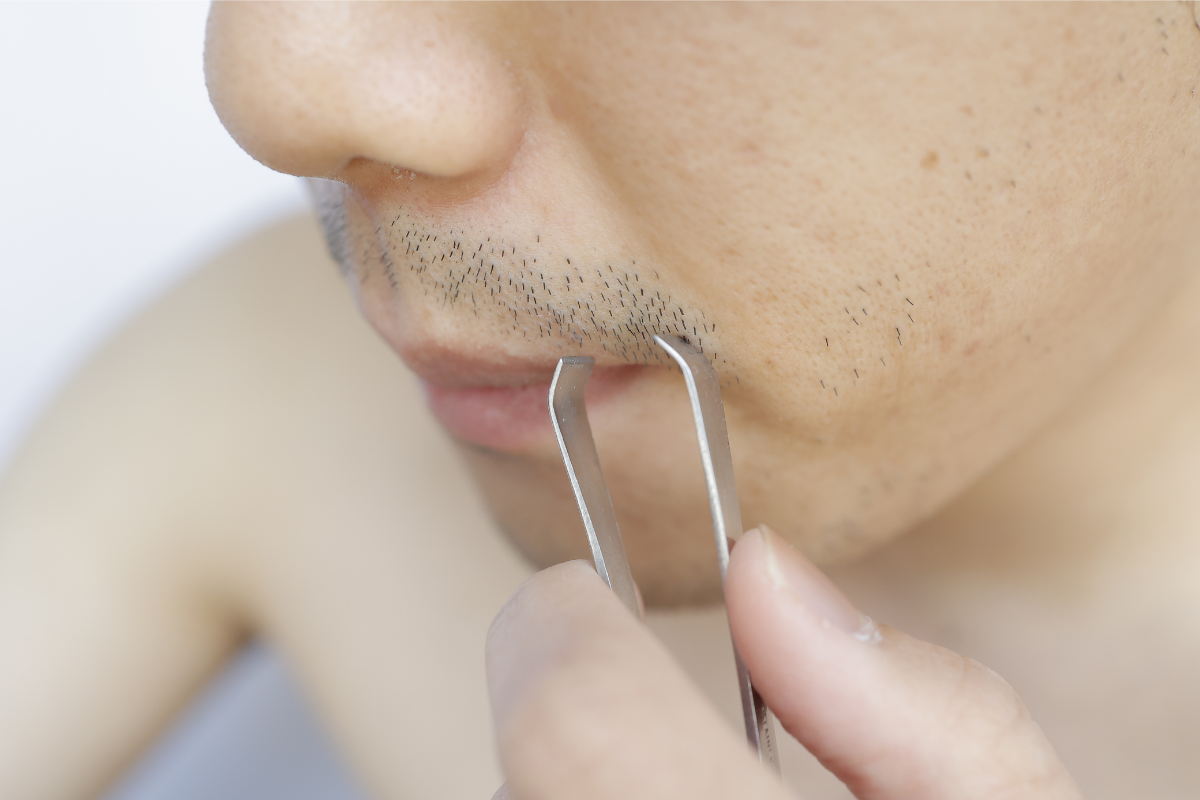ヒゲを抜こうとする男性